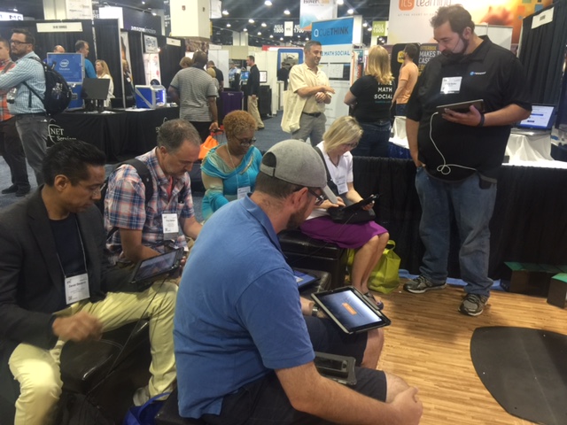 Teachers sitting with iPads at a booth
